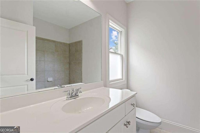 bathroom with vanity, toilet, and a wealth of natural light