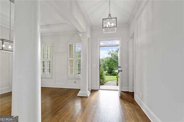 foyer featuring decorative columns, dark wood-type flooring, and ornamental molding