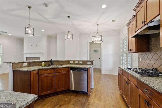 kitchen featuring light wood-type flooring, tasteful backsplash, stainless steel appliances, sink, and pendant lighting