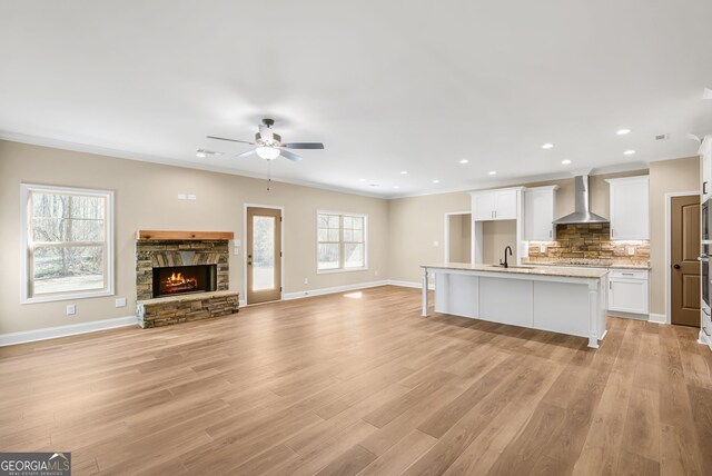 kitchen featuring stainless steel appliances, white cabinetry, a kitchen island with sink, and sink