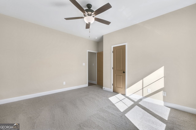 carpeted spare room featuring ceiling fan