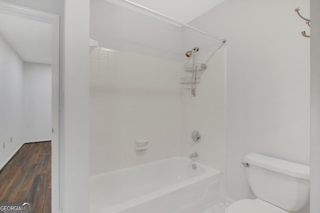 bathroom with wood-type flooring,  shower combination, and toilet