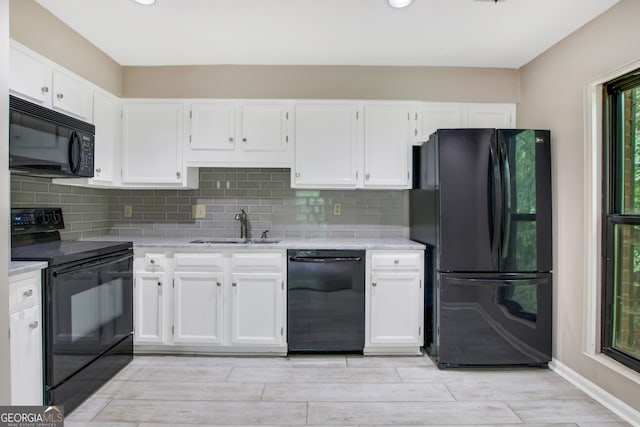 kitchen featuring white cabinets, sink, tasteful backsplash, and black appliances