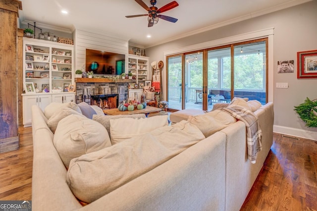 living room featuring ceiling fan, a fireplace, dark hardwood / wood-style floors, and ornamental molding