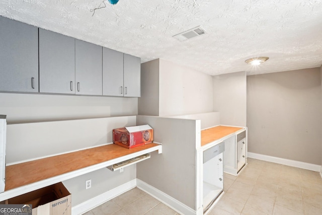 interior space featuring light tile patterned floors and a textured ceiling