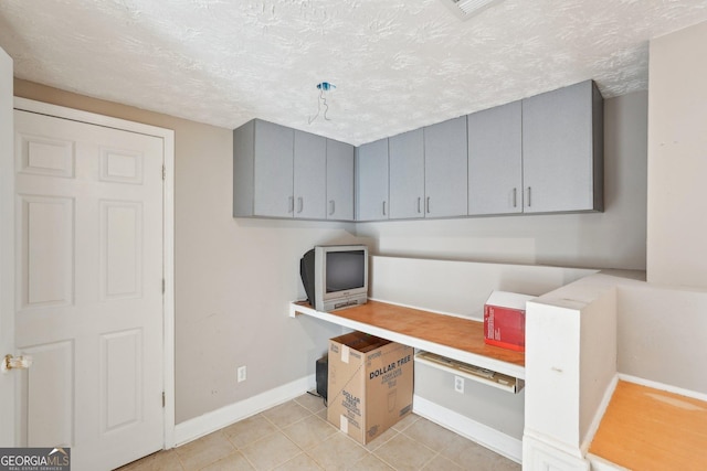 tiled office space with a textured ceiling