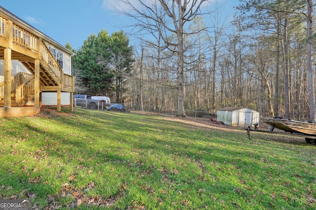 view of yard featuring a deck and a storage shed