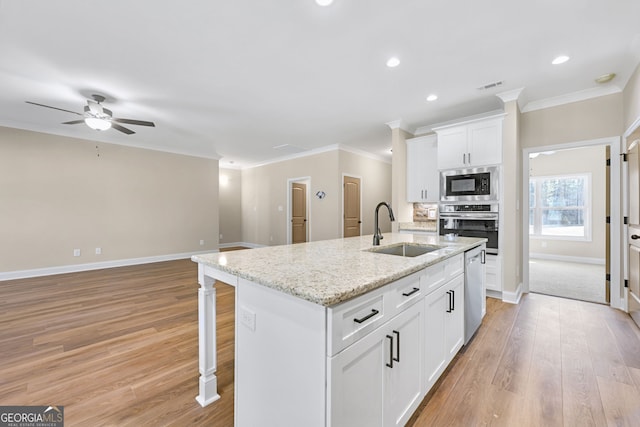 kitchen featuring an island with sink, appliances with stainless steel finishes, sink, and white cabinets