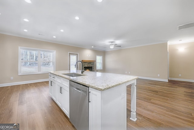 kitchen featuring sink, light stone counters, white cabinets, a center island with sink, and stainless steel dishwasher