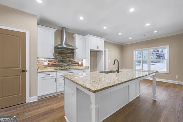 kitchen with wall chimney exhaust hood, white cabinetry, black electric stovetop, light stone countertops, and backsplash