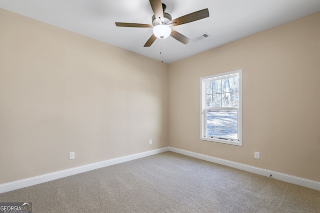 empty room featuring ceiling fan and carpet