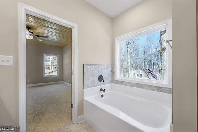 bathroom featuring ceiling fan, a bath, and tile patterned flooring