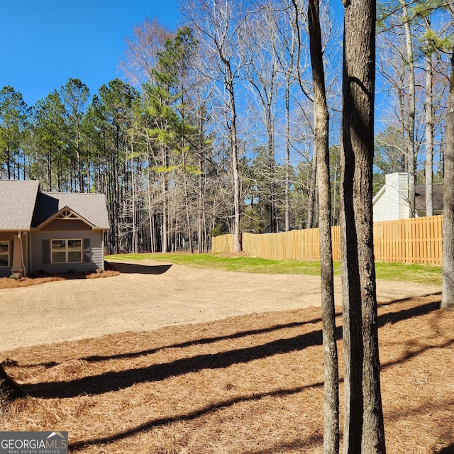 view of yard with fence and driveway