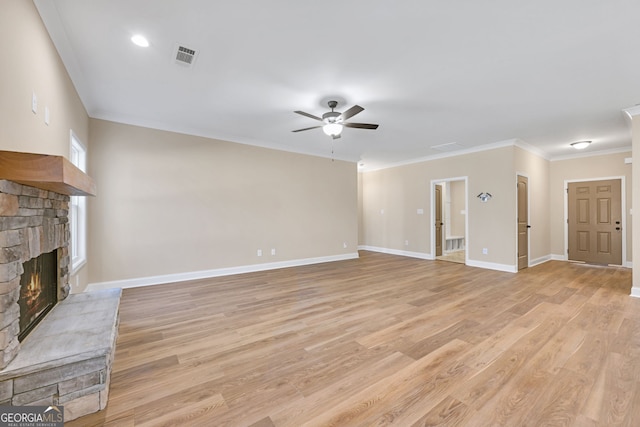 unfurnished living room with crown molding, ceiling fan, a fireplace, and light hardwood / wood-style floors