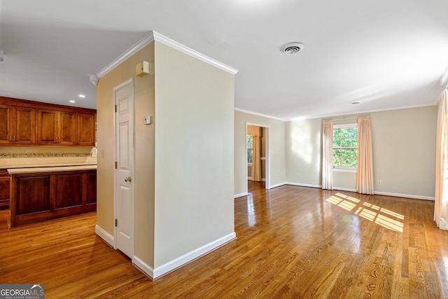 interior space with light wood-type flooring and ornamental molding