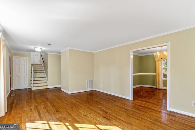 empty room with stairway, wood finished floors, visible vents, and baseboards