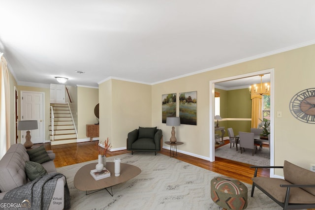 living area featuring stairs, ornamental molding, baseboards, and wood finished floors