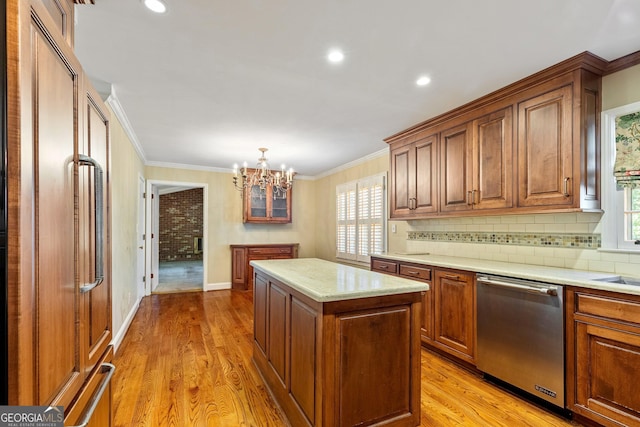 kitchen featuring light wood finished floors, decorative backsplash, a center island, crown molding, and stainless steel dishwasher