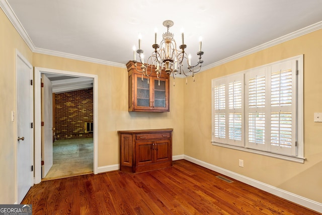 unfurnished dining area with a notable chandelier, dark wood-type flooring, visible vents, baseboards, and crown molding