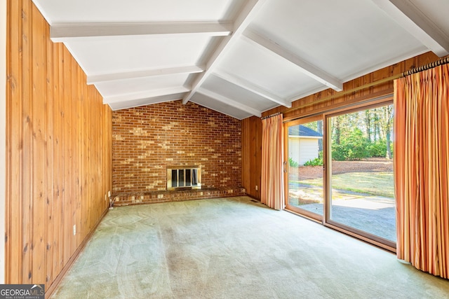 unfurnished living room with brick wall, vaulted ceiling with beams, carpet, wood walls, and a fireplace