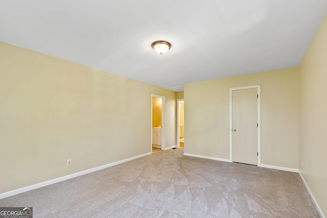 unfurnished bedroom featuring carpet floors, baseboards, and connected bathroom