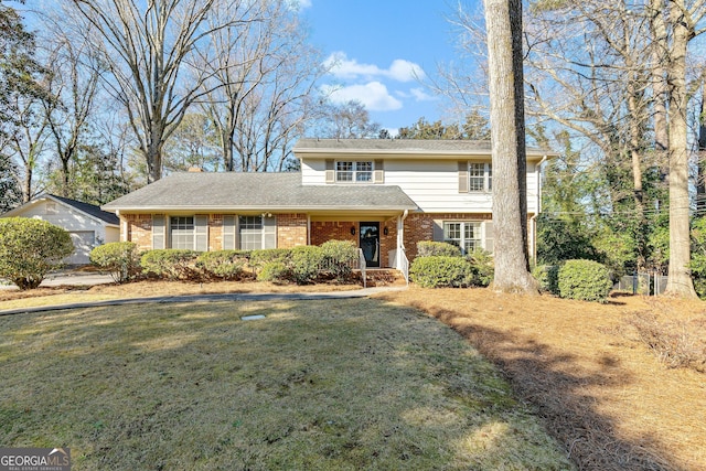 traditional home featuring a front yard and brick siding