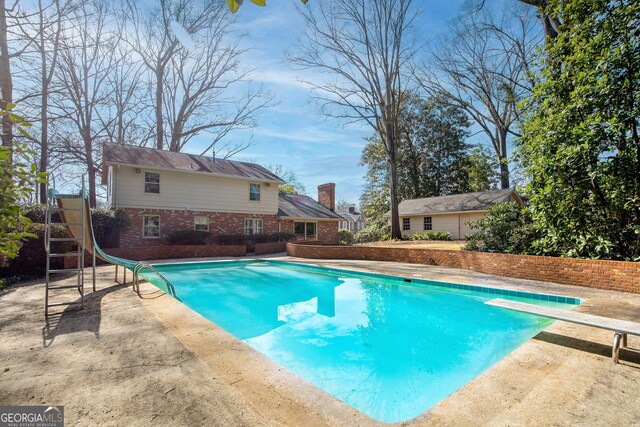 view of pool with a patio area and a water slide