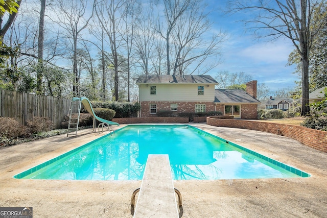 view of swimming pool with a fenced in pool, a water slide, a patio area, and fence