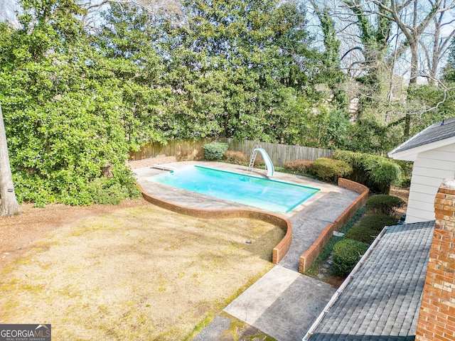 view of swimming pool with a fenced in pool, a water slide, and a fenced backyard