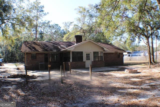 rear view of house with a patio and an outdoor fire pit