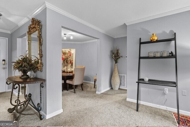 interior space featuring ornamental molding and carpet