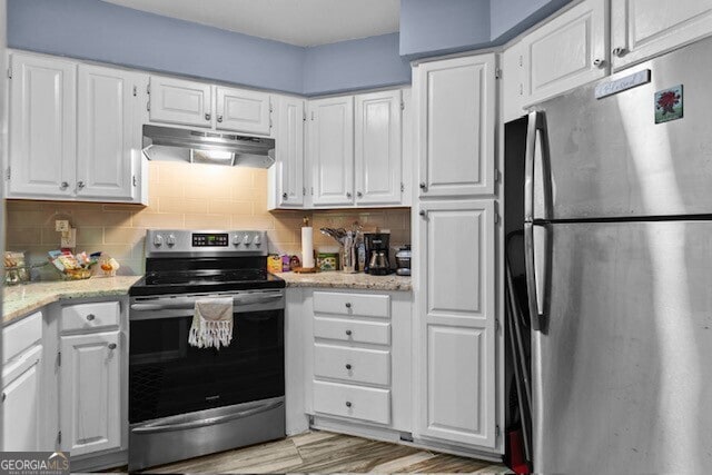 kitchen featuring light hardwood / wood-style flooring, backsplash, stainless steel appliances, light stone countertops, and white cabinets