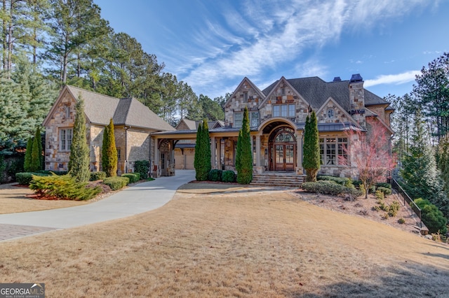 tudor house with french doors and a front yard