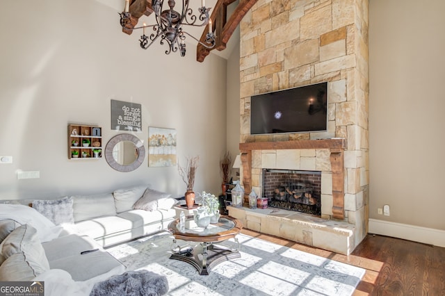 living room with a fireplace, wood-type flooring, and vaulted ceiling with beams