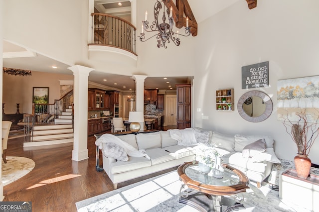 living room featuring a towering ceiling, dark hardwood / wood-style floors, and ornate columns