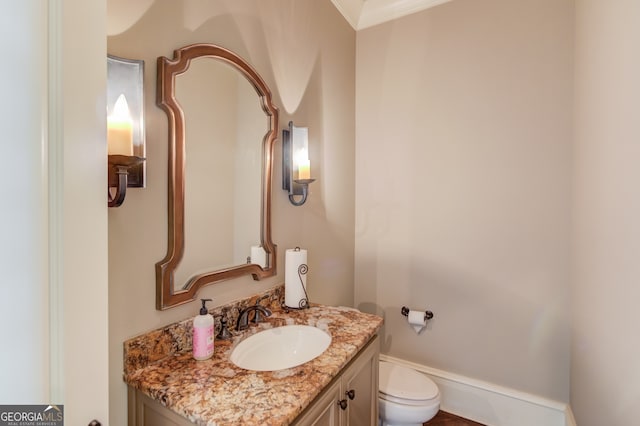 bathroom featuring vanity, toilet, and ornamental molding