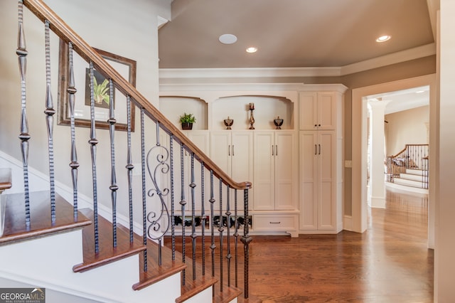 staircase with wood-type flooring and ornate columns