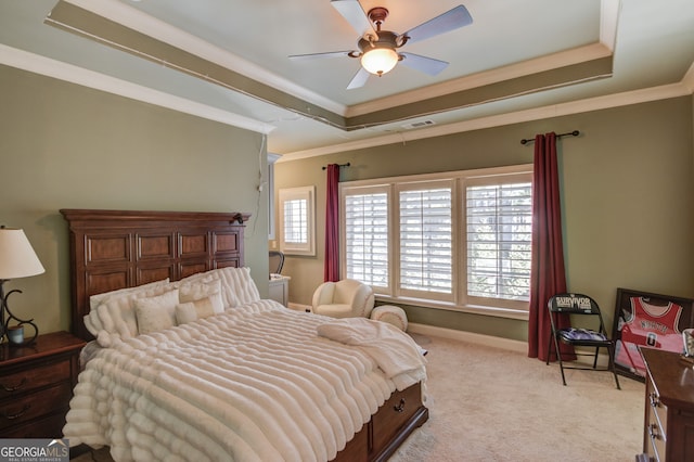 carpeted bedroom with ceiling fan, a raised ceiling, and crown molding