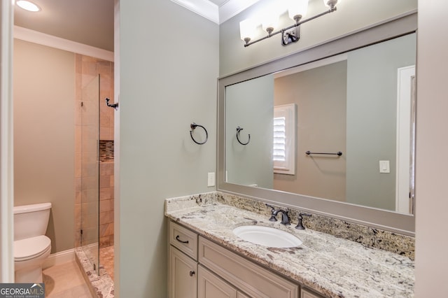 bathroom featuring tiled shower, vanity, toilet, and ornamental molding