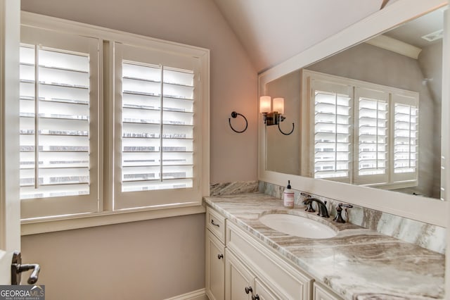 bathroom with vanity and lofted ceiling