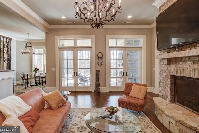 living room with french doors, a stone fireplace, ornamental molding, and dark wood-type flooring