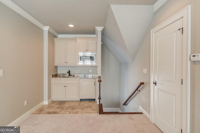 bar with light stone countertops, stainless steel microwave, light colored carpet, and crown molding