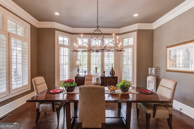 dining room with dark hardwood / wood-style flooring, crown molding, and an inviting chandelier