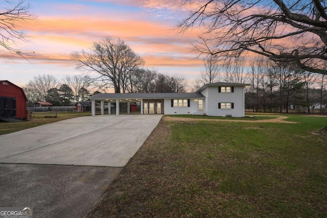 view of front of property featuring a carport and a yard