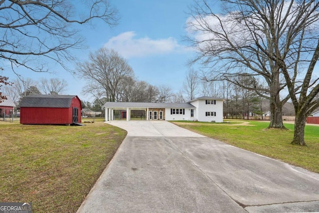 view of front of property with a front yard, a shed, and a carport