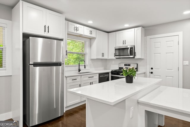 kitchen featuring white cabinetry, appliances with stainless steel finishes, sink, and backsplash