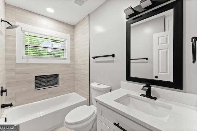 full bathroom with tiled shower / bath, vanity, and toilet