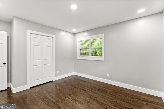 unfurnished bedroom featuring dark hardwood / wood-style floors and a closet