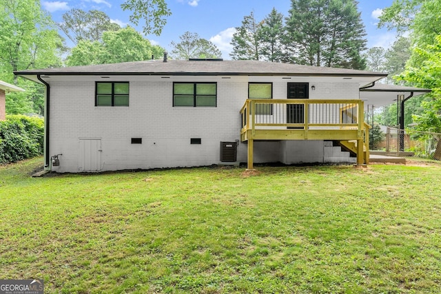 back of property with a yard, central AC unit, and a deck