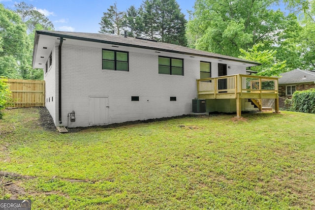 back of house featuring a wooden deck, a lawn, and central air condition unit